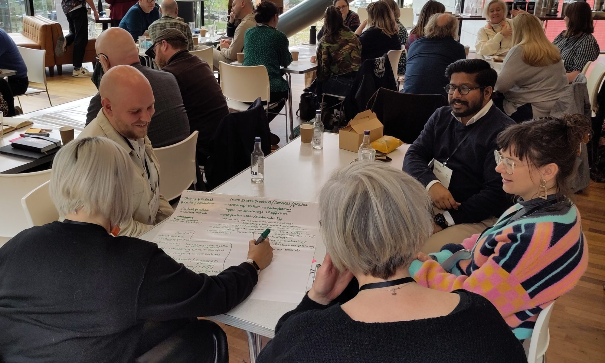 People smiling and talking in a group discussion