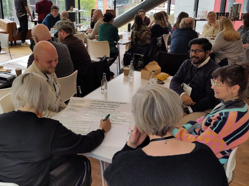 People smiling and talking in a group discussion