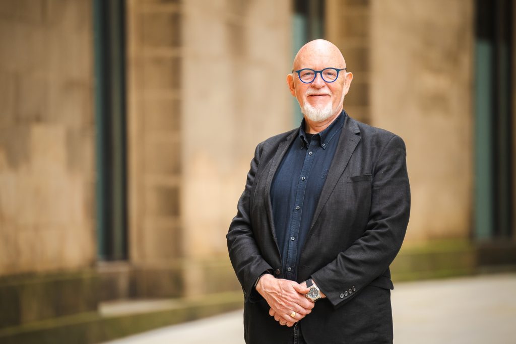 Photograph of Dave Moutrey, a white man with a grey beard smiling at the camera.