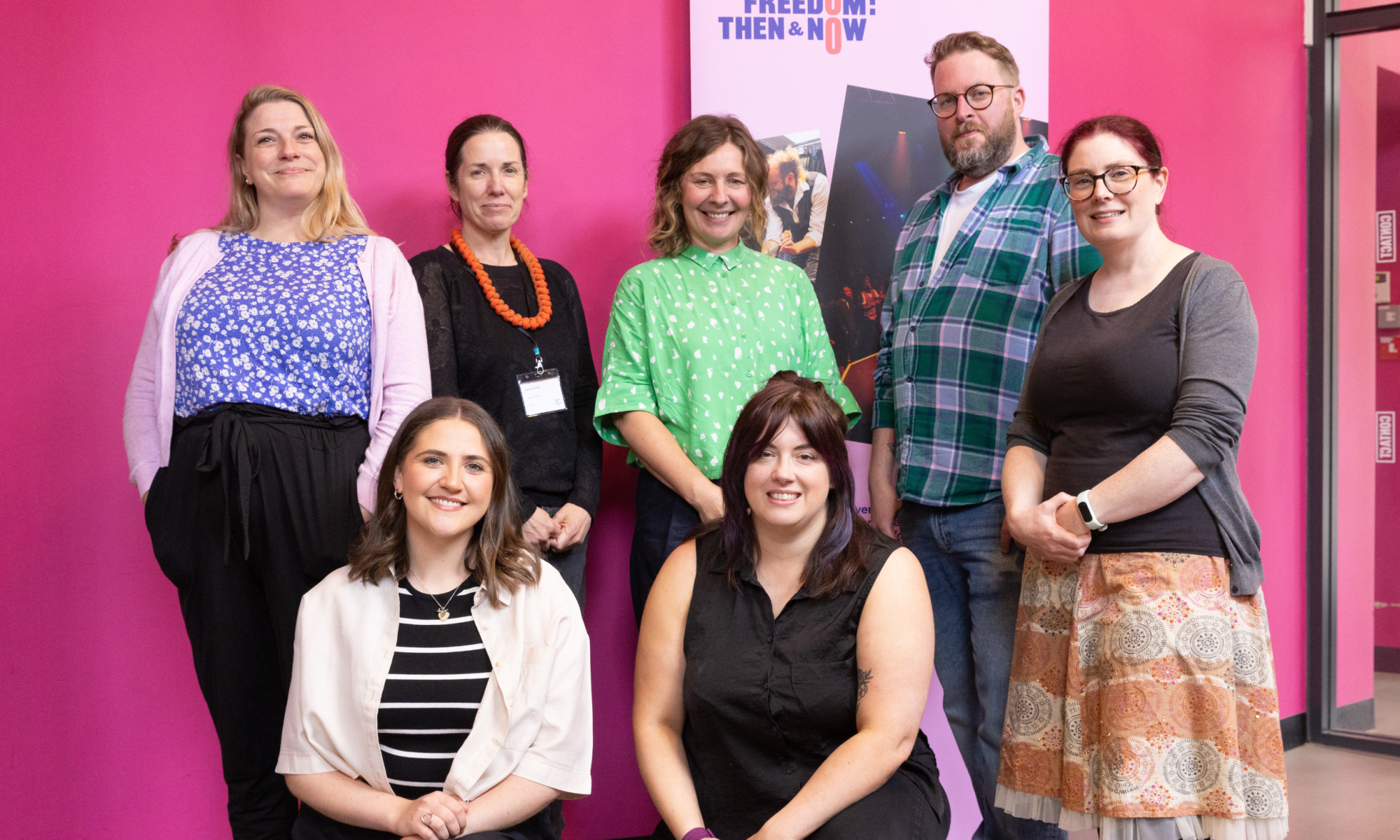A posed shot of a group of seven people (five standing and two kneeling) - the six Our Freedom Cluster Coordinators, plus Simon Savidge of Libraries Connected.
