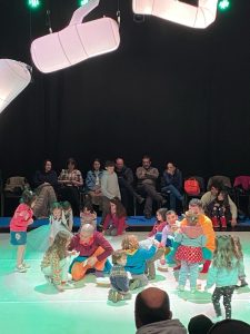 Children on stage interacting with the performers from A Forest (Chile)