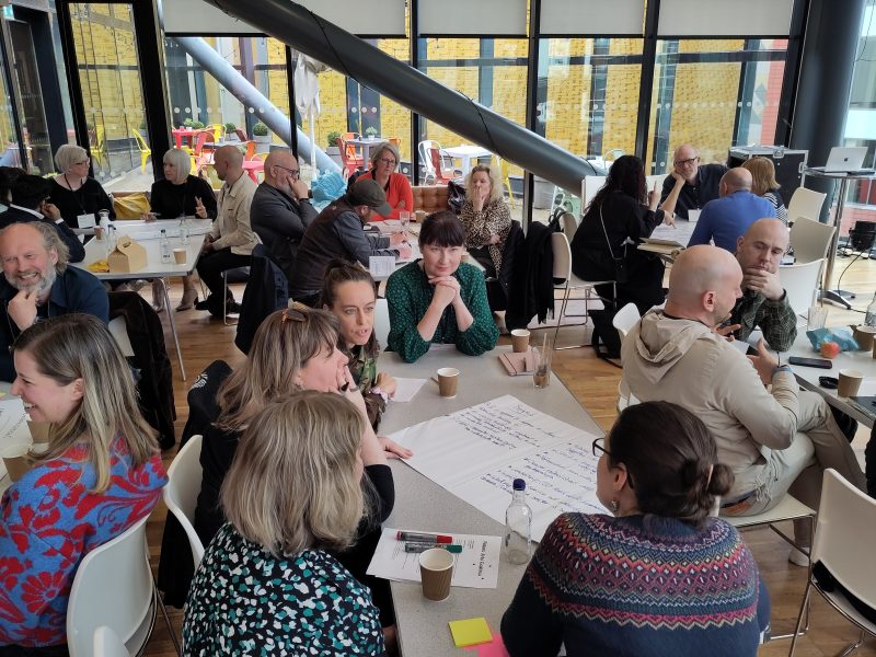 Groups of people talking around tables