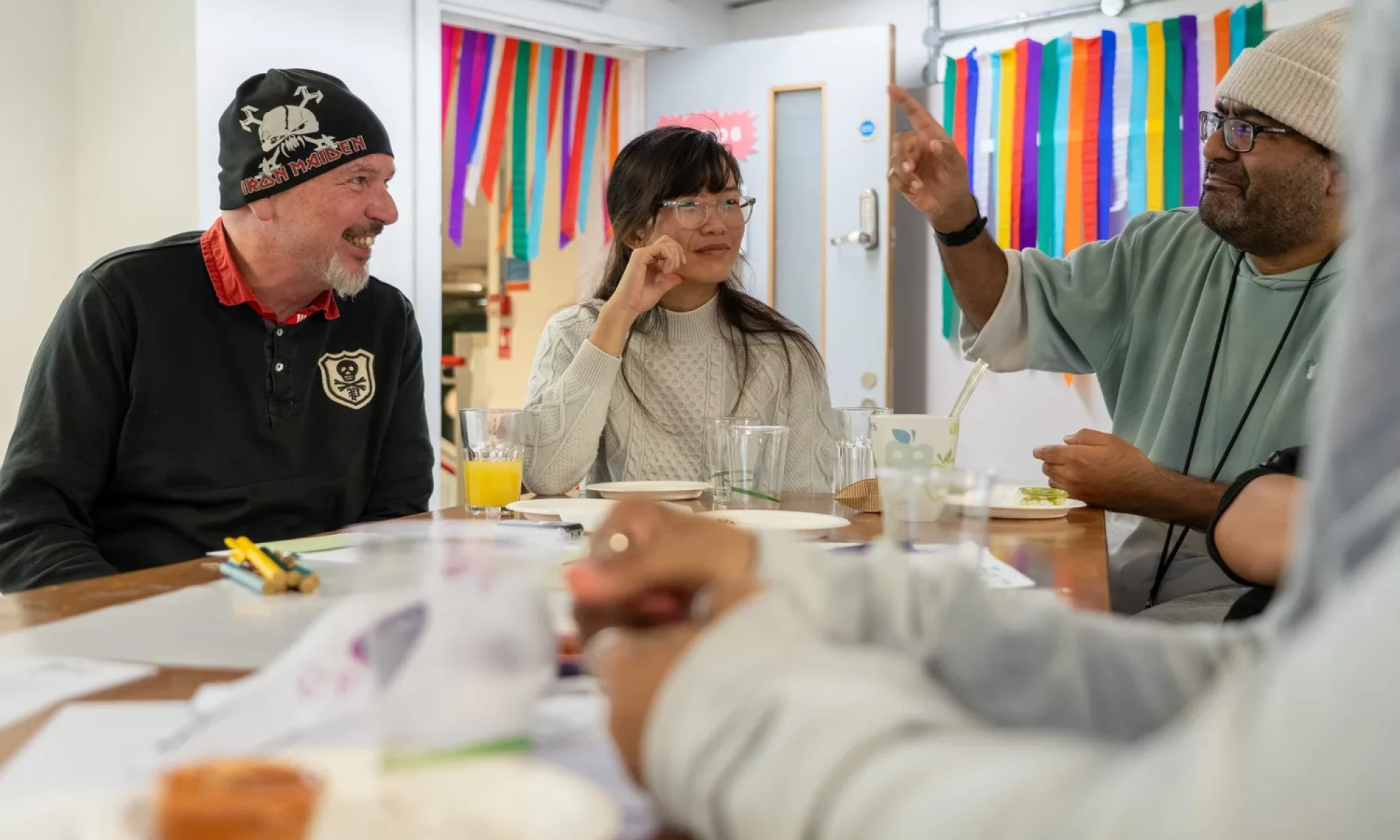 People smiling as they sit around a table and talk